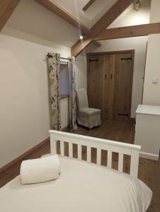 a bedroom with a white bed and a chair at The cottage in Alston