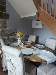 a dining room table with chairs and a wooden table with plates at The cottage in Alston