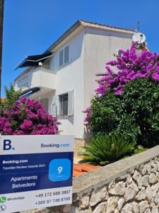 a sign in front of a house with purple flowers at Silba Belvedere (2) 45m from the beach in Silba