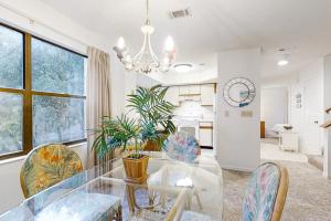 American BeachにあるTwo-story townhome with fast WiFi & pool - steps from the beachのガラスのテーブルと椅子のあるダイニングルーム