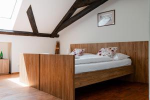1 dormitorio con cama de madera y armario de madera en Rezidence U Kamenného mostu, en Písek