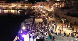 a crowd of people standing on a pier at night at L'Ancora in Bisceglie