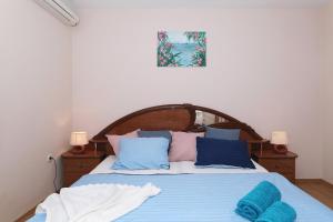 1 dormitorio con 1 cama con almohadas azules y rosas en Villa Ella - swimming pool, garden, baby friendly, en Bast