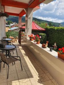 un patio avec tables et chaises sur un balcon dans l'établissement Casa Marian, à Buşteni