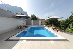 una piscina al lado de una casa en Villa Ella - swimming pool, garden, baby friendly, en Bast