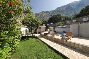 un patio trasero con bancos, piscina y montañas en Villa Ella - swimming pool, garden, baby friendly, en Bast