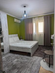 1 dormitorio con cama y pared verde en Downtown Retreat "Spiranca" en Tirana