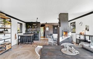 eine Küche und ein Wohnzimmer mit einem Tisch und einem Kamin in der Unterkunft Nice Home In Gilleleje With Wifi in Gilleleje