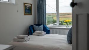 Blackberry Cottage - Newly renovated cosy cottage في Malborough: غرفة نوم عليها سرير وفوط