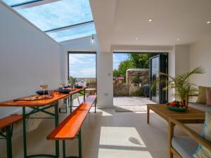 a dining room with a long table and benches at Blackberry Cottage - Newly renovated cosy cottage in Malborough