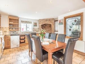 a kitchen with a dining room table and chairs at Dovedale Cottage in Coningsby