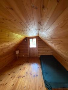 a large room with a bed in a wooden cabin at MK Kodumajutus in Võrumõisa