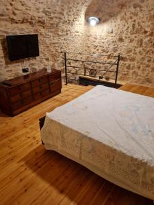 a bedroom with a bed and a flat screen tv at Village home in Chios