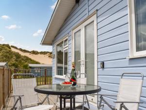 a patio with a table and chairs and a house at Bows Pad in Gwithian