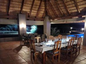 a dining room with a white table and chairs at Thandolwami Bushlodge & Spa in Hoedspruit