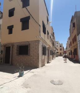 a person walking down a street next to a building at Dar Sevilla in Asilah +1 photo