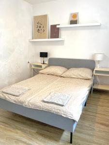 ein Schlafzimmer mit einem Bett mit zwei Tischen und Regalen in der Unterkunft Apartament Pola Śródmieście in Gdynia