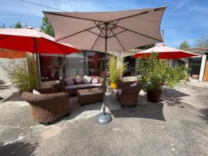 un grand parasol, des chaises et un canapé dans l'établissement Mas de la Butte Blanche, à Orgon