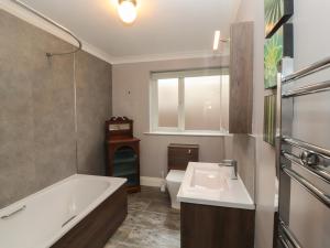 a bathroom with a tub and a sink and a toilet at Fern Lee in Carlisle