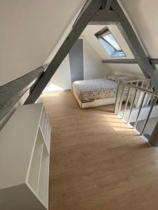 Cette chambre mansardée comprend deux lits et un escalier. dans l'établissement L’Embrun, à Dieppe