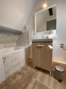 La salle de bains est pourvue d'un lavabo, d'une baignoire et d'un miroir. dans l'établissement L’Embrun, à Dieppe