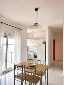 cocina y comedor con mesa de madera y sillas en Dimitra House Entire apartment with balcony and view, en Pherrai