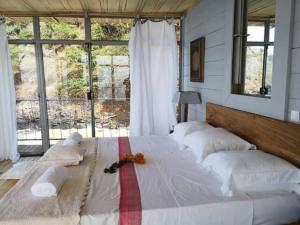 duże łóżko w pokoju z dużym oknem w obiekcie Mawo house w mieście SantʼAna