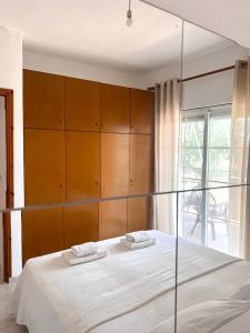 1 dormitorio con 1 cama y armario de madera en Dimitra House Entire apartment with balcony and view, en Pherrai