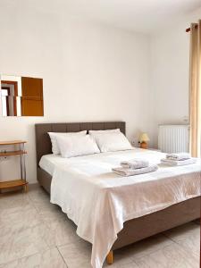 um quarto com uma grande cama branca com toalhas em Dimitra House Entire apartment with balcony and view em Pherrai