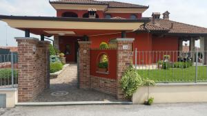 a red house with a gate and a fence at Villa Laura B&B in Fossano