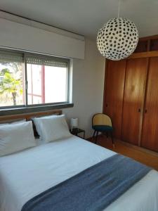 a bedroom with a large bed and a pendant light at Casa Capuchos. Close to Lisbon with Ocean View in Caparica