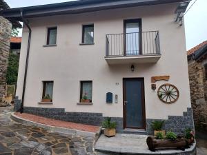 a white house with a balcony and a door at La corte in Vezzo