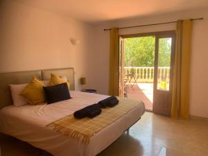 een slaapkamer met een bed en een glazen schuifdeur bij Casa Hermosa Mijas in Mijas