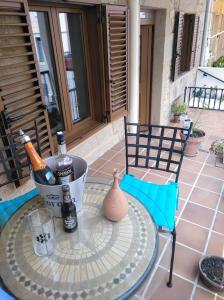 a table with bottles of wine and a vase on a patio at Casa Vily in Vilagarcia de Arousa