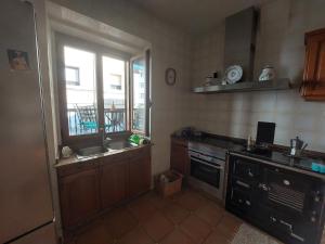 a kitchen with a sink and a stove and a window at Casa Vily in Vilagarcia de Arousa +17 photos