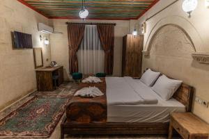 a bedroom with a bed and a desk in a room at Cordial Cappadocia Hotel in Ortahisar