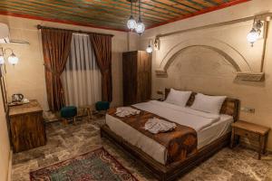 a bedroom with a bed and a table and chairs at Cordial Cappadocia Hotel in Ortahisar