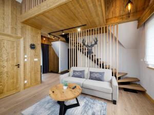 a living room with a couch and a table at Apartamenty Górski Prestige in Białka Tatrzanska