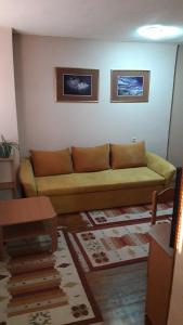 a living room with a couch in the corner of a room at Modern&Cozy Bosnian house with GARDEN+FREE parking in Sarajevo