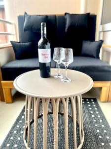 a bottle of wine and two wine glasses on a table at Trafalgar Apartment 133 in Cuxhaven