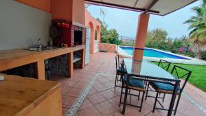 een patio met een tafel en stoelen en een zwembad bij Villa Pilarín in Málaga