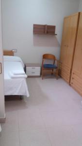 a bedroom with a bed and a chair in it at Residencial Oscense in Huesca