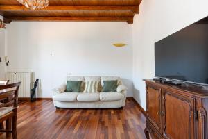 ein Wohnzimmer mit einem weißen Sofa und einem Flachbild-TV in der Unterkunft Porta Romana M3- Cosy apartament in Mailand