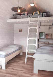 Habitación con litera, 2 camas y escalera. en Tiny House en Chvalšiny