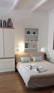 a bedroom with a large bed with towels on it at Sa Frummiga in Cagliari