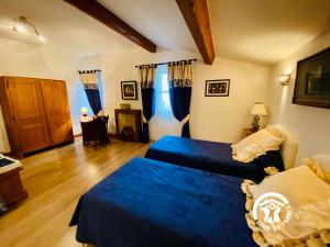 a bedroom with two beds with blue sheets at Château Borie Neuve in Badens