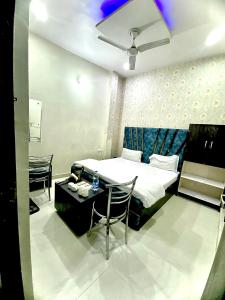 1 dormitorio con 1 cama, mesa y sillas en Swaran hotel, en Amritsar