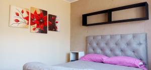 um quarto com uma cama e duas pinturas na parede em Esencia Cabaña em Potrerillos
