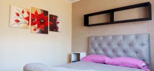 a bedroom with a bed and two paintings on the wall at Esencia Cabaña in Potrerillos