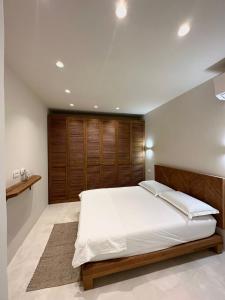 a bedroom with a large bed with a wooden headboard at White Pearl Villa in Dhërmi